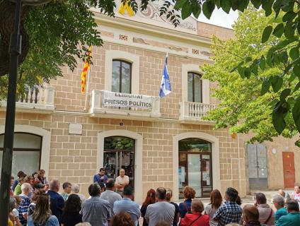 La façana de l'Ajuntament llueix el llaç groc i la pancarta